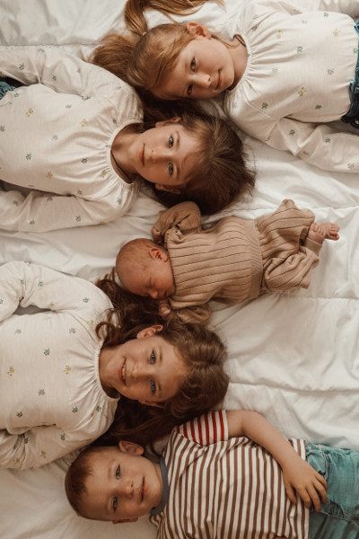 Kinder, die nebeneinander auf einem Bett liegen bei einem Fotoshooting für Familien & Kinder in Dresden