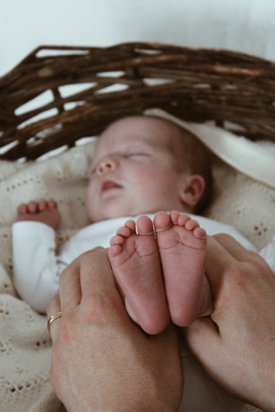 Ein schlafendes Baby in einem alten Holzkorb bei einem Fotoshooting für Neugeborene in Dresden